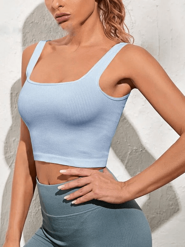 Woman wearing blue seamless sports top with pushup effect, designed for breathability and comfort during workouts.